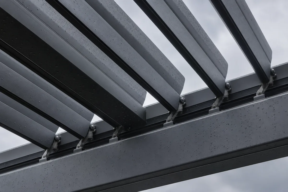 Pergola bioclimatique en aluminium gris anthracite adossée à une maison bourguignonne, lames orientables entrouvertes sous un ciel d&rsquo;automne